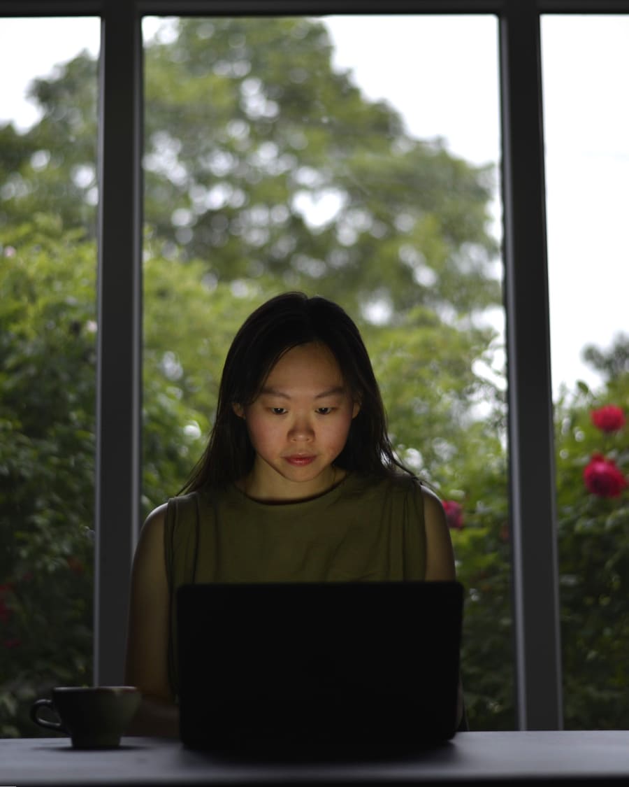 Linda Wang travaillant sur son ordinateur portable pour ses clients cherchant une approche humaine à l'adoption de l'intelligence artificielle.