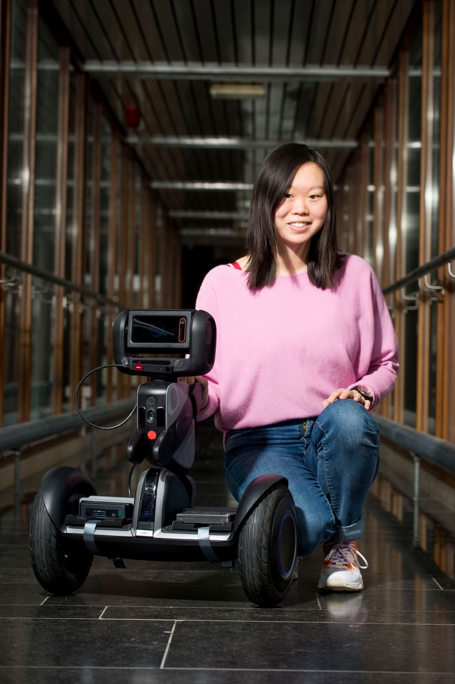Linda Wang aux côtés d'un robot Loomo, lors de ses recherches en IA à l'ULiège